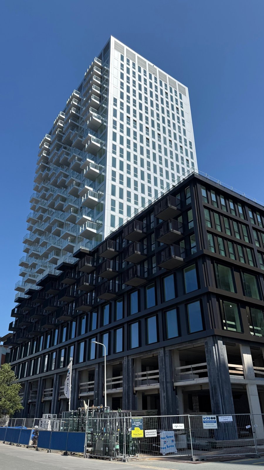 ビンクホルストに建つ分譲タワー「One MilkyWay」。タワーは完成していても足元にはまだ工事フェンスが残る